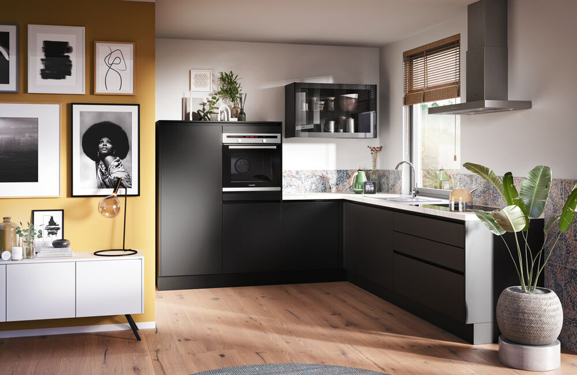 Greeploze zwarte keuken met een bovenkast met glas