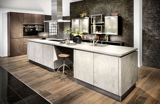 Design keuken met groot kookeiland in beton-look gecombineerd met een wandkast in de kleur mokka